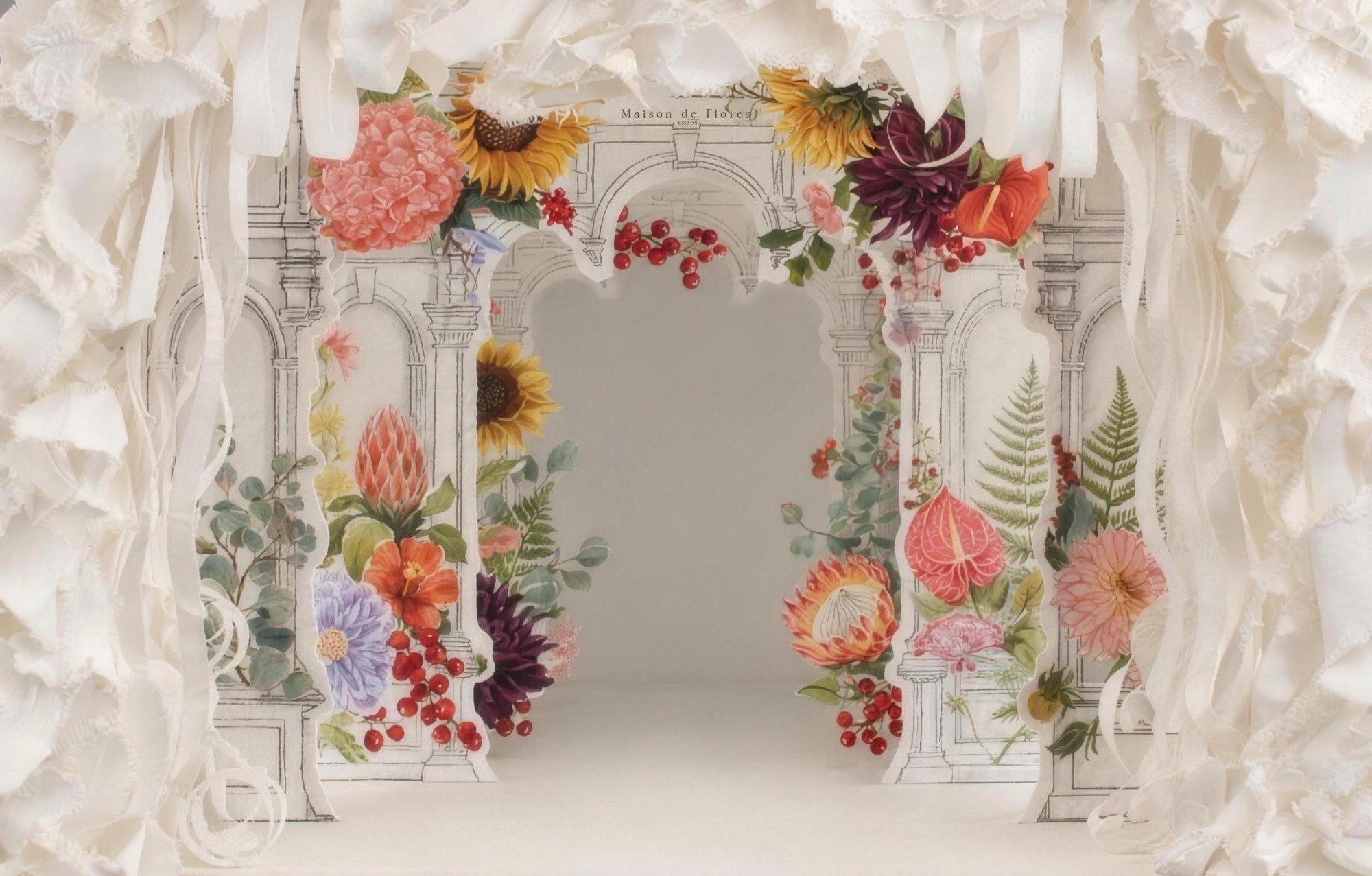 A paper theatre of torn paper, drawn architecture and pressed flowers